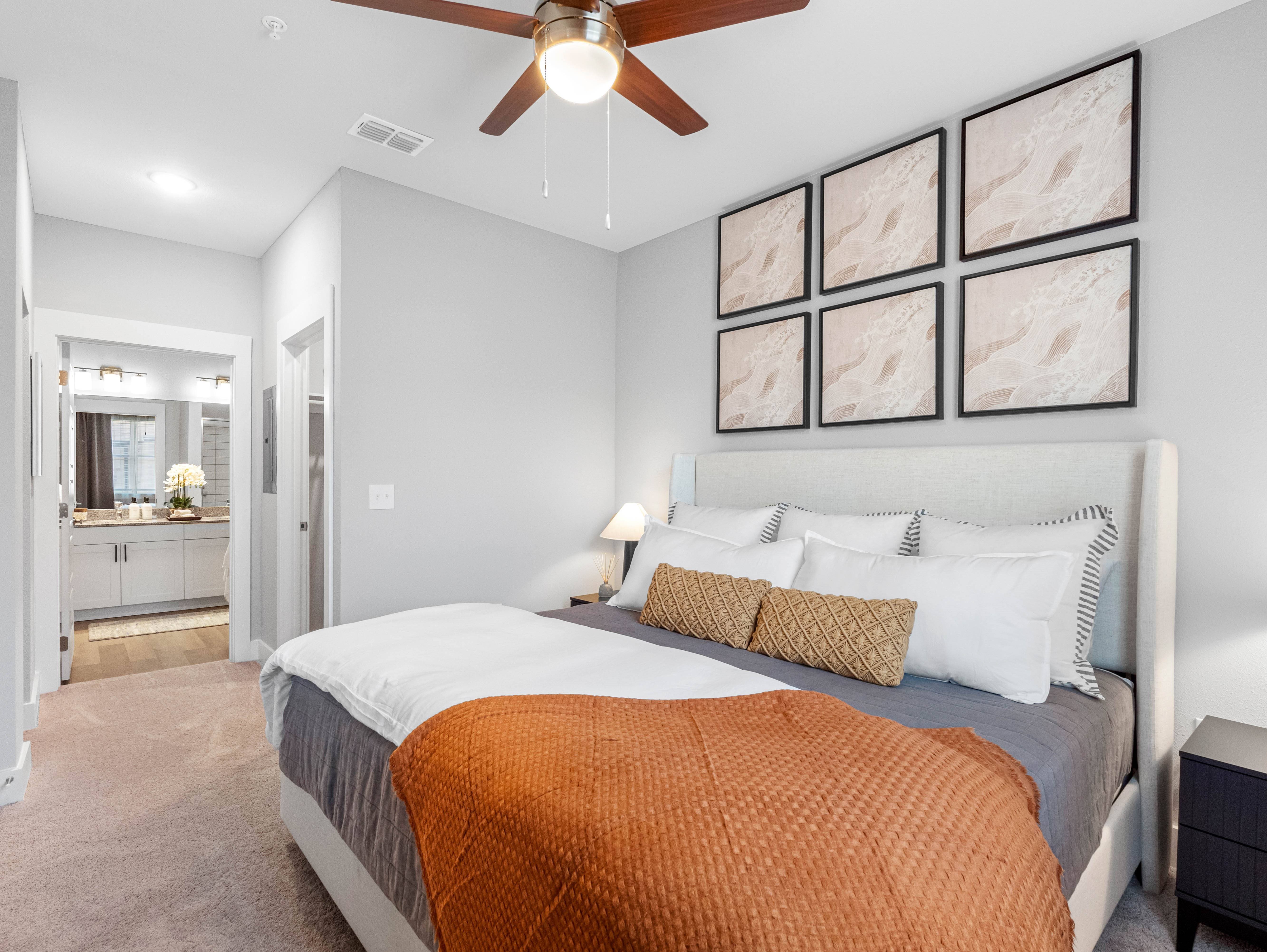 A bedroom with a large bed and a ceiling fan.